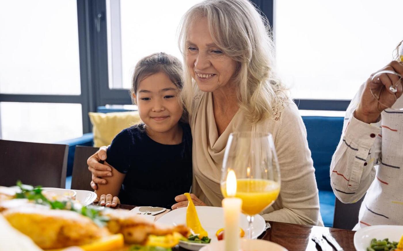Elderly woman and grandchild having dinner together